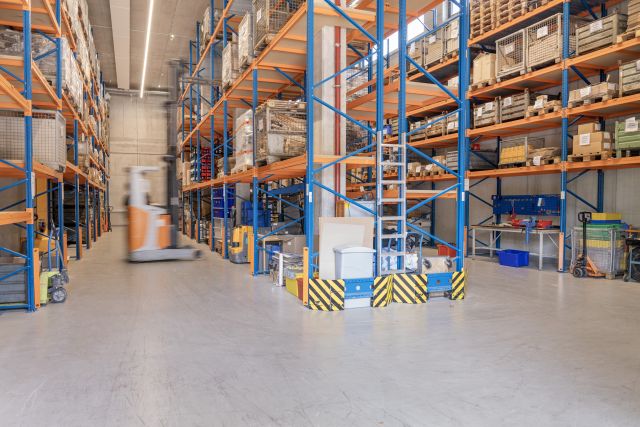 Blick in eine Lagerhalle der Remstal Werkstätten mit zahlreichen Hochregalen.