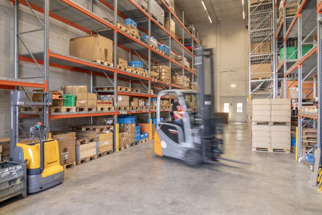Blick in eine Lagerhalle der Remstal Werkstätten mit zahlreichen Hochregalen.